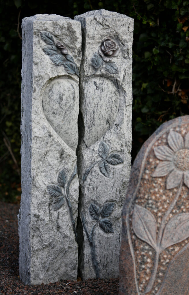 Mindesten med udhugget hjerte og roser symboliserer evig kærlighed og respekt.