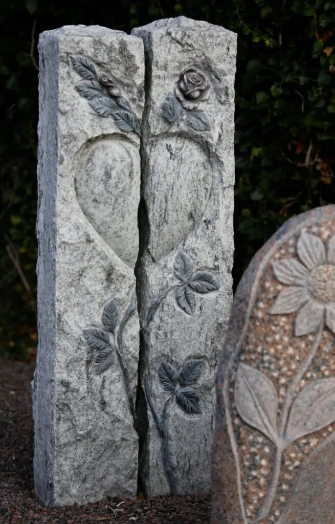 Mindesten med udhugget hjerte og roser symboliserer evig kærlighed og respekt.
