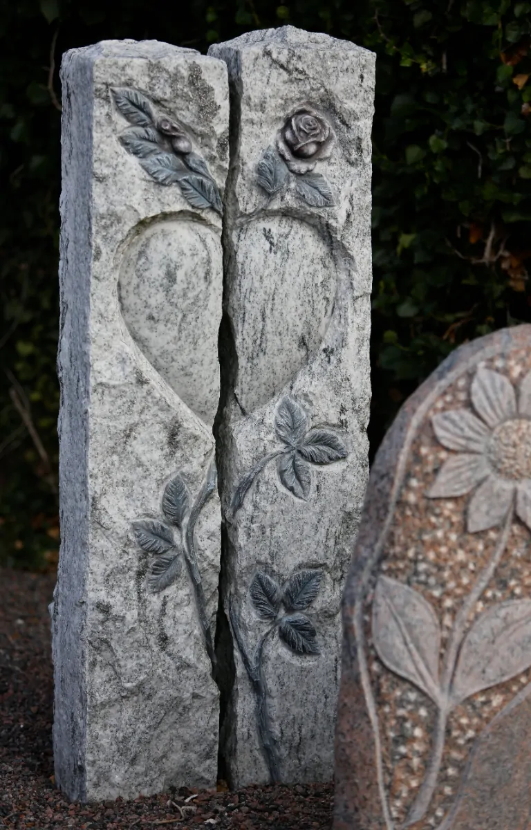 Mindesten med udhugget hjerte og roser symboliserer evig kærlighed og respekt.